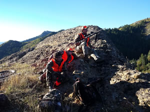 The boys sitting on a cliff elk hunting